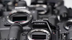 Panasonic Lumix camera body in sharp focus among several other camera bodies in soft focus background.