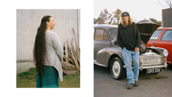 Woman with long dark hair wearing a cream cardigan and teal skirt stands in profile against a white wall.