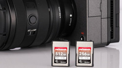 Two Prograde Digital memory cards displayed in front of a camera body and lens.