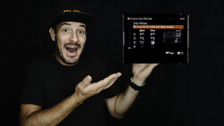 Screenshot of camera dial/wheel settings menu displayed on a smartphone screen held by a man in a black cap.