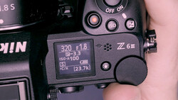 Close-up of a Nikon Z6 III camera's rear LCD screen and control buttons displaying shooting settings.