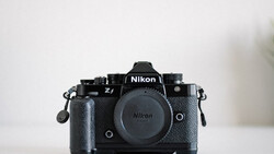Nikon Z f mirrorless camera body with attached battery grip against white background.