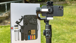 Smartphone gimbal with mounted phone and accessory kit displayed on white product card.