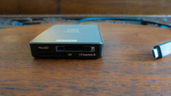 Multi-card reader with MicroSD, SD, and CFexpress B slots on a wooden surface with blue cable.