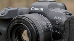 Canon EOS R5 mirrorless camera with Canon RF 50mm f/1.8 lens attached, shown in sharp focus against a blurred background.