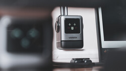 UGREEN USB hub mounted on a monitor arm with desk setup visible in background.