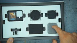 Overhead view of a camera accessory kit with protective cases and lens attachments displayed in custom foam.