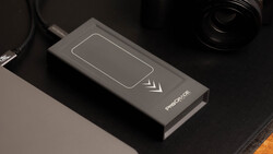 Wireless charging pad with smartphone icon and directional arrows on dark surface.