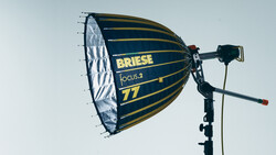 Briese Focus.2 77 parabolic softbox mounted on a light stand against a light sky backdrop.