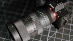 Sony mirrorless camera with attached telephoto zoom lens on a calibration chart surface.