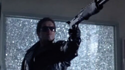 Person in sunglasses and dark clothing aiming a rifle with scope toward bright, sparkly windows.