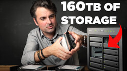 Man holding an external hard drive storage unit with multiple bays, displaying 160TB capacity text.