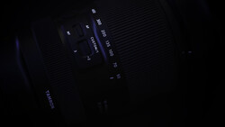Close-up of camera lens markings and aperture settings in low light.