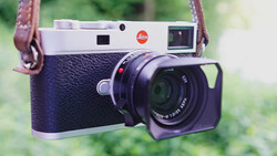 Leica M rangefinder camera with blue crocodile leather body and brown leather shoulder strap.