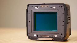 Rugged portable device with a teal-colored CRT display and metal frame, photographed against a neutral beige background.