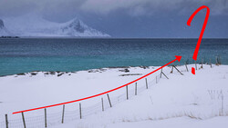 Snowy beach with fence line and red directional arrow overlay pointing upward across the landscape.