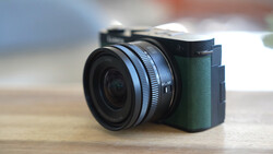 Compact mirrorless camera with attached wide-angle lens on wooden surface.