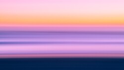 Serene seascape with layered horizontal bands of soft pink, purple, and blue tones during twilight hour.