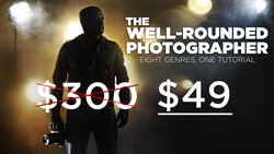 Photographer holding lighting equipment against dark background with studio lights.