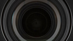 Concentric circular lens elements receding into darkness, showing internal optical glass geometry.