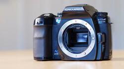 Konica Minolta Dynax 5 DSLR camera body with lens mount exposed, positioned against neutral background.
