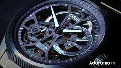 Close-up of an Oris luxury watch with exposed skeleton dial showing internal mechanisms and blue-toned case against dark background.