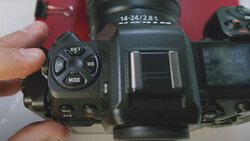Close-up of camera control dial showing BKT, WB, and MODE buttons with lens labeled 14-24/2.8 S in background.