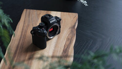 Nikon Z-series mirrorless camera body displayed on a wooden platform with natural window lighting.