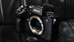 Sony α mirrorless camera body with exposed sensor and mount, displayed against dark fabric backdrop.