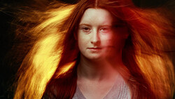 Portrait of a woman with long red-orange hair against a dark background with warm golden lighting.