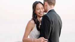 Bride and groom embracing during portrait session with soft studio lighting.