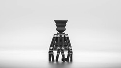 Minimalist black and white photograph of a sculptural tripod-like structure with a tapered vessel on top, set against a hazy horizon.