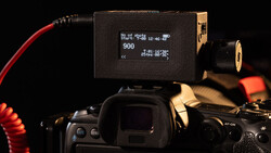 External monitor mounted on a DSLR camera showing 900 shots recorded with timecode display and shooting details.