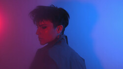Person in profile against a gradient background transitioning from magenta to blue.