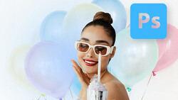 Woman wearing white-framed sunglasses and red lipstick touches her face near colorful balloons.