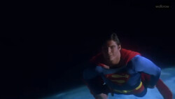 Person in superhero costume flying horizontally against dark background.