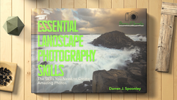 Book cover for 'Essential Landscape Photography Skills' by Darren J. Spoonley featuring a dramatic coastal landscape.