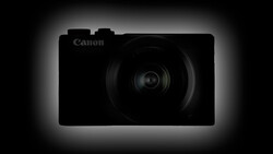 Canon compact digital camera silhouetted against a dark background with rim lighting.