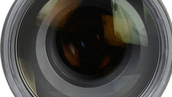 Close-up frontal view of a camera lens showing internal glass elements and aperture mechanism.