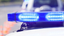 Blue LED emergency light bar mounted on a vehicle roof with bokeh background.