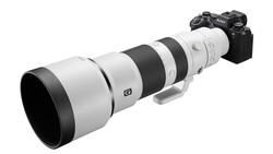 Sony mirrorless camera with white and black telephoto zoom lens mounted on top.