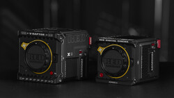 Two RED digital cinema cameras with black bodies and gold-accented lens mounts displayed side by side.