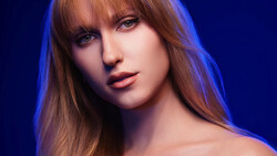 Portrait of a woman with auburn hair and bangs against a deep blue background.