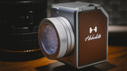 Hasselblad medium format camera with vintage lens and leather body on wooden surface.