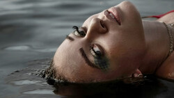 Person floating on their back in water with eyes closed and serene expression.