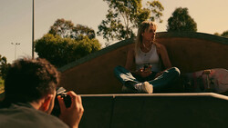 Photographer shooting a portrait of a woman sitting in a truck bed during golden hour.