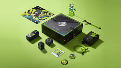 Flat lay of a collector's box set with action figures, trading cards, and accessories arranged on a bright yellow-green background.