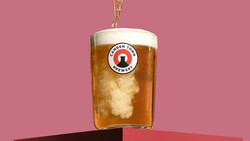 Beer being poured into a glass with brewery logo against a pink background.