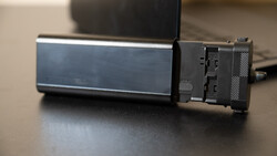 External hard drive with blue metallic casing and black connector module on desk surface.