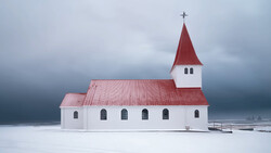 White wooden church with red roof and steeple standing alone on a frozen lake under stormy skies.